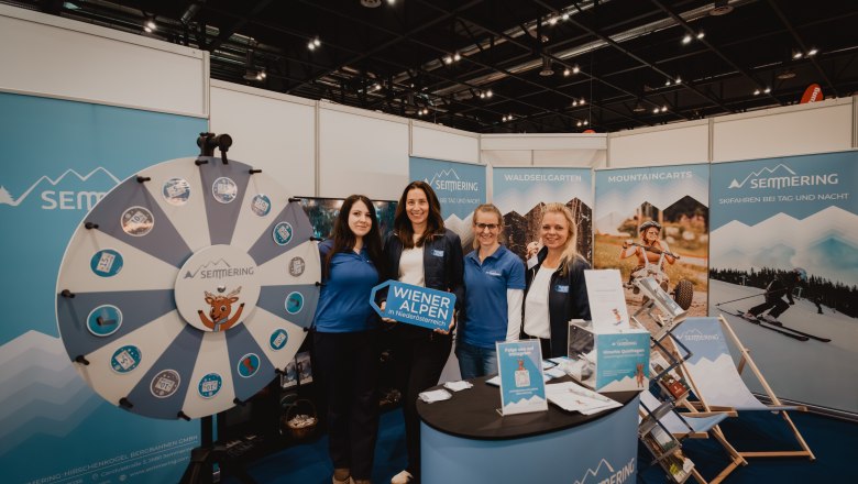 Gruppe vor Gl&uuml;cksrat mit wiener Alpen Schild 