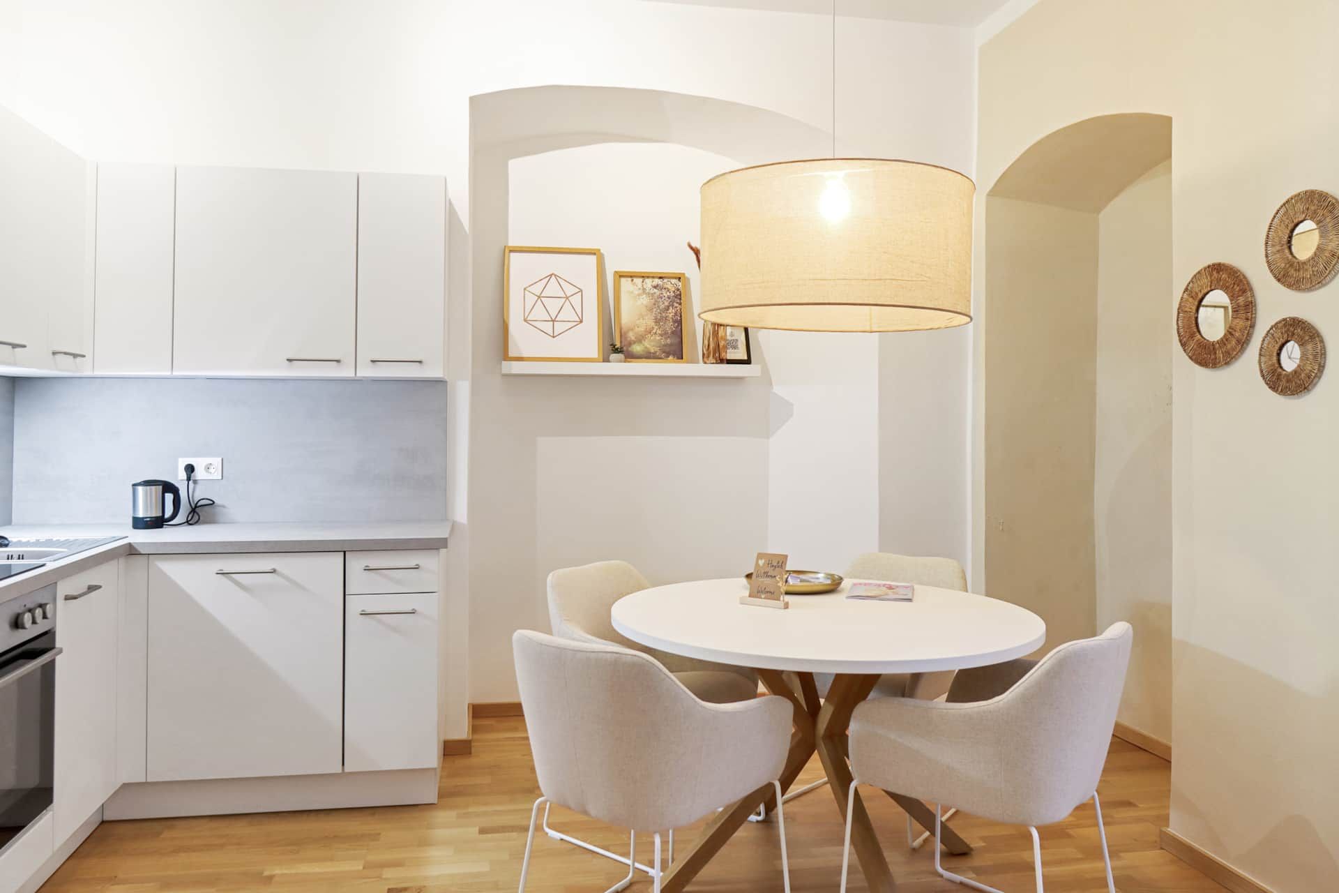 Heller Essbereich mit Küche, Esstisch, Stoffstühlen und Boho-Deko