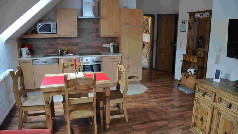 Gemütliche Ferienwohnungsküche mit Holzmöbeln und Esstisch.