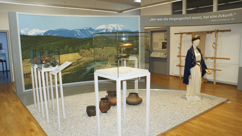 Innenansicht des Pittener Regionsmuseums mit Ausstellungsstücken und Wandgemälde.
