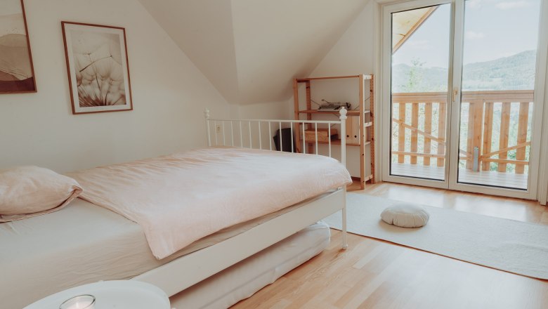 Helles Schlafzimmer mit Bett, Balkon und minimalistischer Einrichtung.