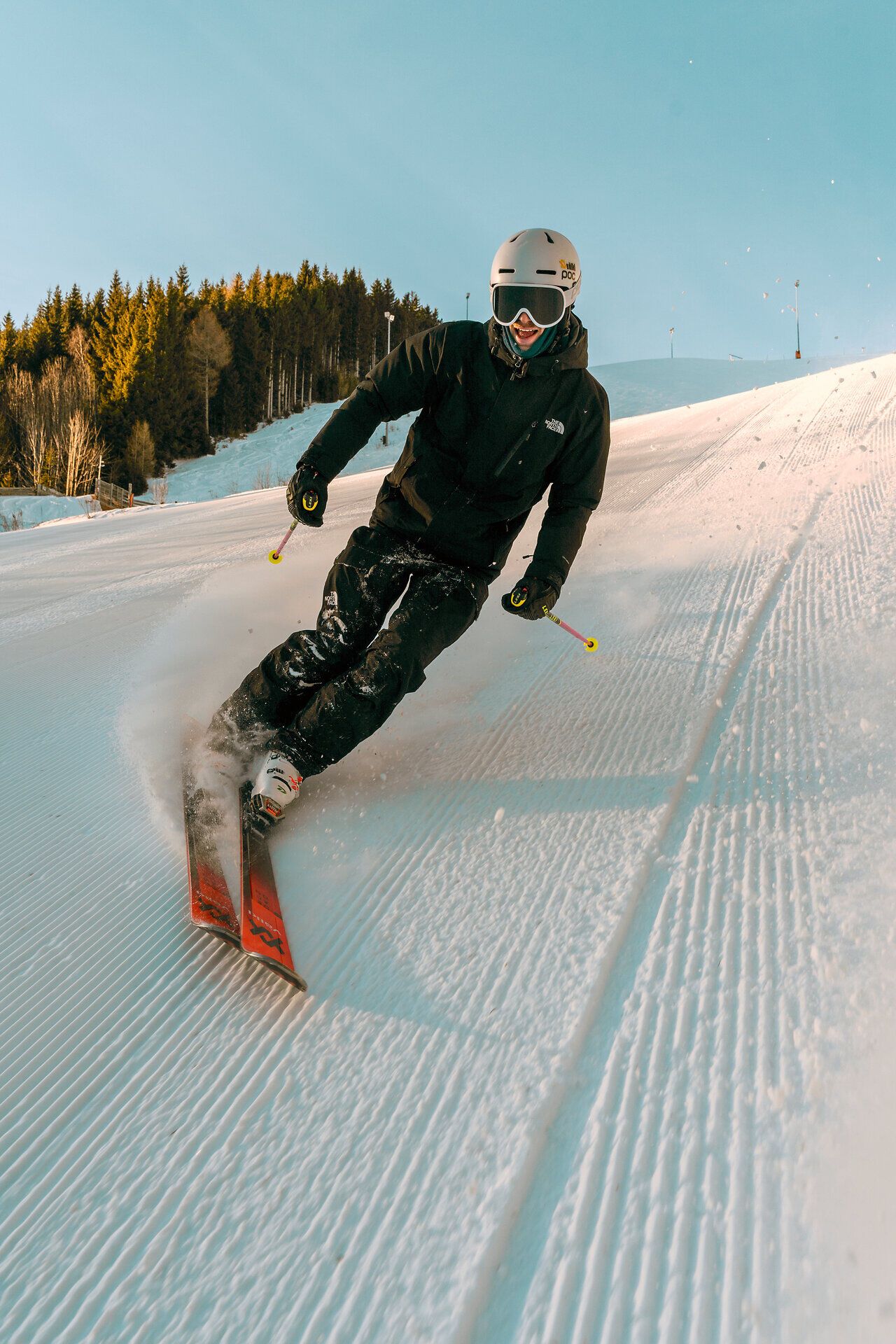 Skifahrer bei einer sportlichen Abfahrt auf der präparierten Piste am Semmering Hirschenkogel.