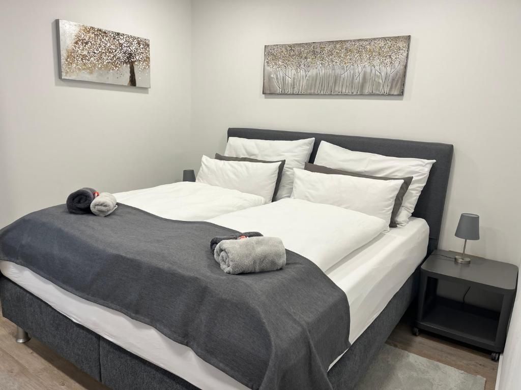 Comfortable box-spring bed with bedside cabinet and pictures on the wall