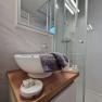 Modern bathroom with washbasin, mirror and shower.