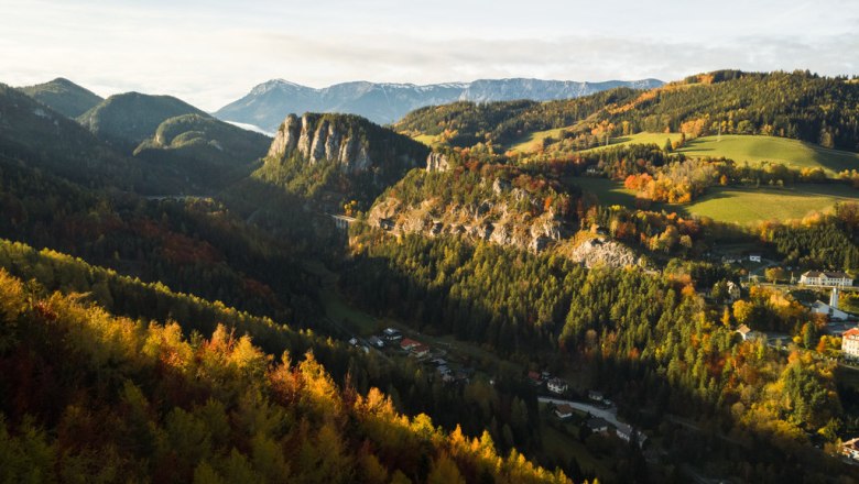 Luftaufnahme der Semmeringbahn und Pollereswand in herbstlicher Landschaft.
