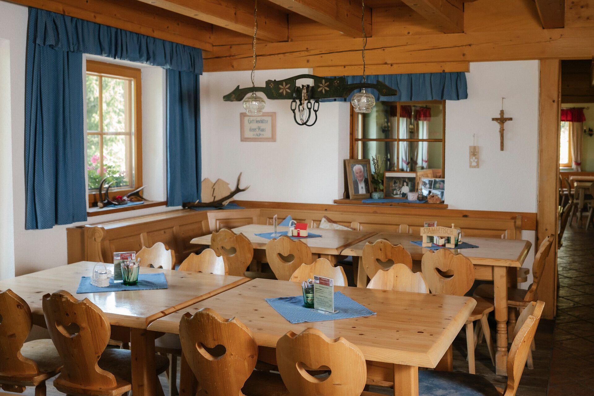 Gastraum mit Herzstühlen und blauen Vorhängen in der Hengsthütte am Schneeberg