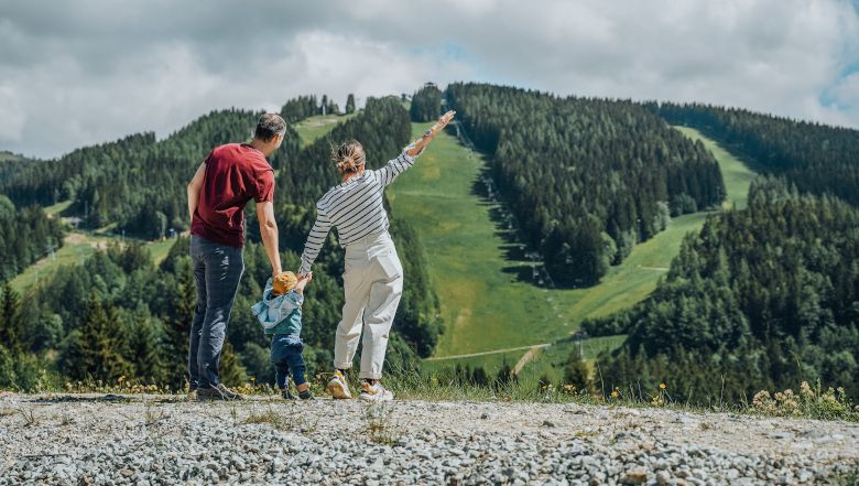 Familie blickt auf bewaldeten Berg am Semmering.
